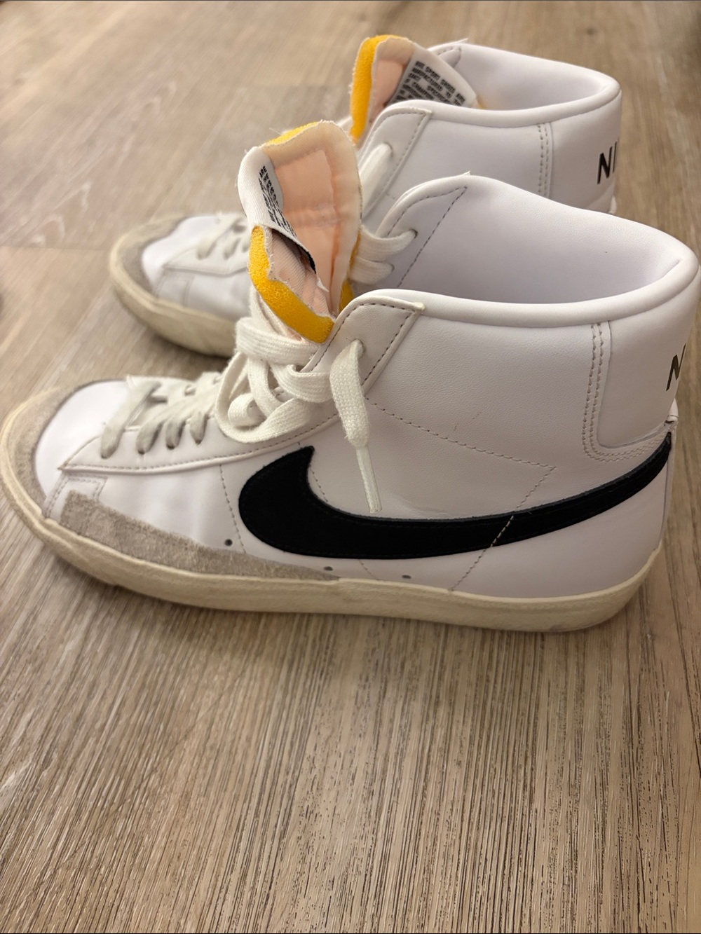 Nike White High-Top Sneakers with Black Swoosh and Yellow Tongue